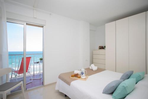 a bedroom with a bed and a view of the ocean at Apartments Cullera Beach in Cullera