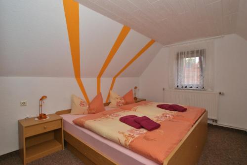 ein Schlafzimmer mit einem Bett mit orangefarbenen und gelben Streifen in der Unterkunft Ferienhaus Schaffrath in Ehrenberg
