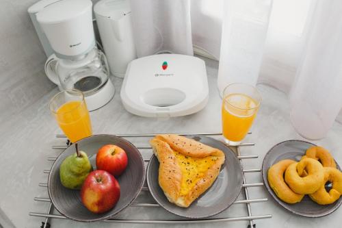 uma mesa com dois pratos de comida e dois copos de sumo de laranja em Viva Mare Traditional Studios em Astypalaia