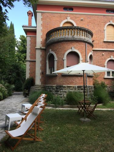 a group of chairs and an umbrella in front of a building at Rooms Portorose Center in Portorož