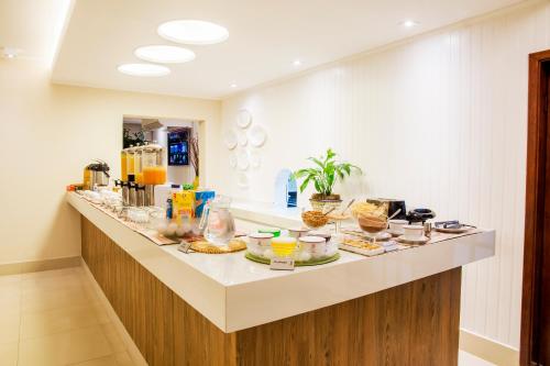 a long counter with food on it in a room at JR Hotel in Presidente Prudente