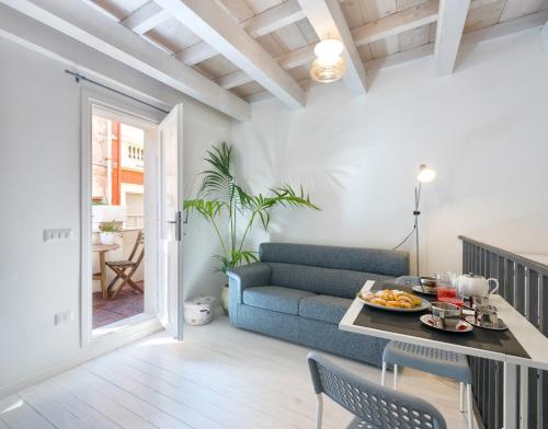uma sala de estar com um sofá azul e uma mesa em Castelletto Suite La Marina em Cagliari