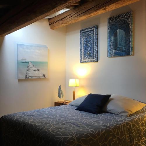 une chambre avec un lit et des tableaux au mur dans l'établissement Lunel Bien-etre, à Lunel