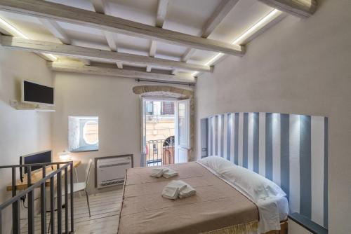 um quarto com uma cama com duas toalhas em Castelletto Suite La Marina em Cagliari
