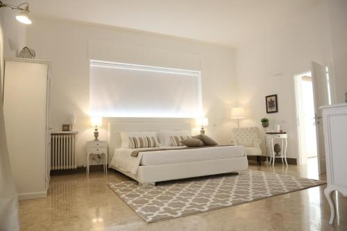ein weißes Wohnzimmer mit einem weißen Bett und einem Teppich in der Unterkunft Dimi House in Lecce