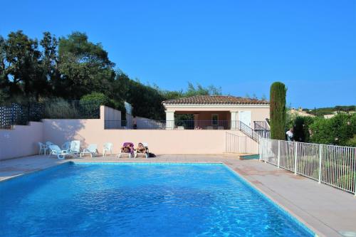 une piscine devant une maison dans l'établissement Appartement les Pins Bleus A8, à Sainte-Maxime