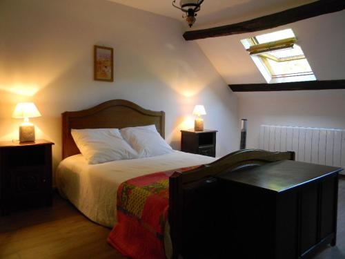 een slaapkamer met een bed met 2 nachtkastjes en 2 lampen bij L'Etang in Val Couesnon