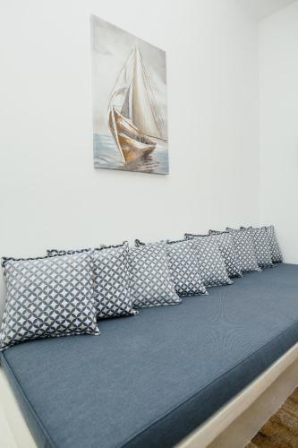 a bed with pillows and a picture of a boat at Viva Mare Traditional Studios in Astypalaia