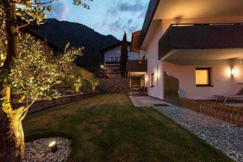 a house with a tree in the middle of a yard at Apartment Zielspitz in Parcines