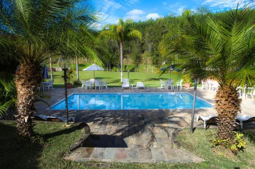 a swimming pool with palm trees in a yard at Fazenda Alvorada in Cunha