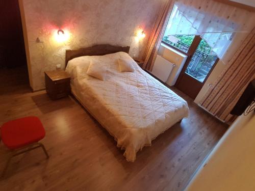 1 dormitorio con cama blanca y ventana en Casa Presecan, en Tălmăcel