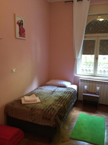a bedroom with a bed and a window at Rooms Portorose Center in Portorož