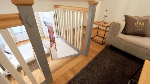 a living room with a couch and a stairway at Anno 1433 Hotel Lüneburg in Lüneburg
