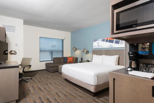 a hotel room with a bed and a flat screen tv at Hyatt House Austin/Downtown in Austin
