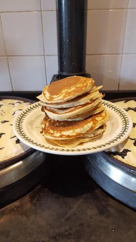 einen Stapel Pfannkuchen auf einem Teller auf einem Herd in der Unterkunft The Old Stables Bed & Breakfast in Shepton Mallet