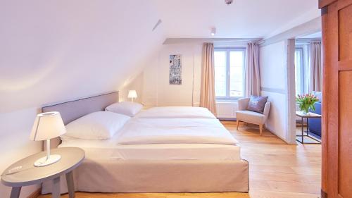 a bedroom with a bed and a table and a chair at Anno 1433 Hotel Lüneburg in Lüneburg