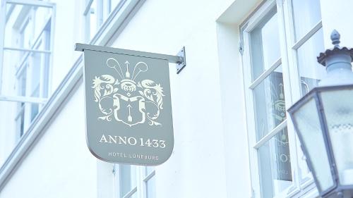 a sign hanging on the side of a building at Anno 1433 Hotel Lüneburg in Lüneburg