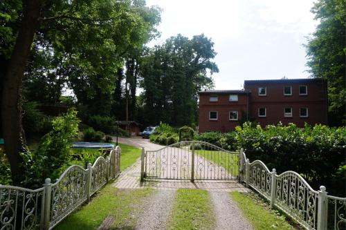 a gate in a garden with a building in the background at Ferienwohnung am Mühlenpark in Timmendorfer Strand