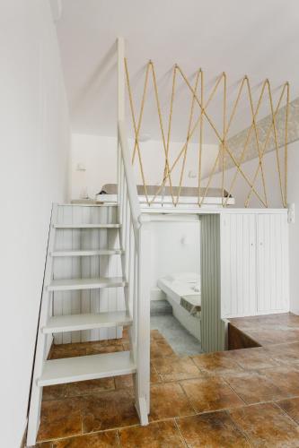 a white bunk bed with a ladder in a room at Viva Mare Traditional Studios in Astypalaia