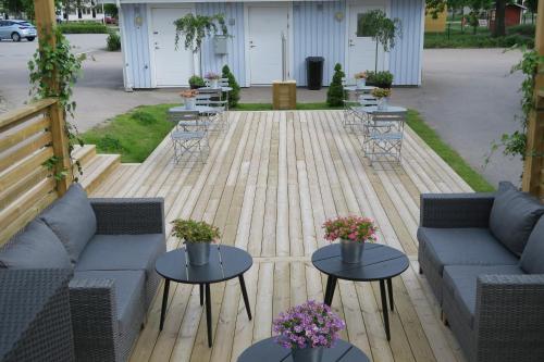 a patio with two couches and tables and chairs at Easy Livin' Apartment Hotel in Växjö