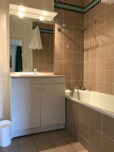 une salle de bain avec une baignoire et un lavabo et une baignoire dans l'établissement Appartement T3 Luchon, à Luchon