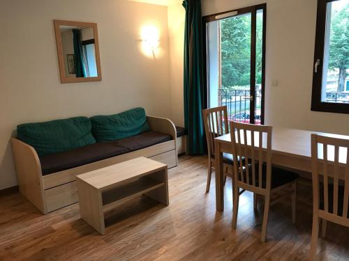 a living room with a couch and a table at Appartement T3 Luchon in Luchon