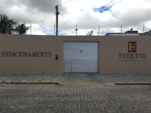 ein Gebäude mit einer Garagentür und einem Schild darauf in der Unterkunft Etiqueta Hotel in Santa Cruz do Capibaribe
