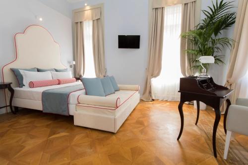 a bedroom with a bed and a chair and a piano at Residenza Degli Artisti in Trieste