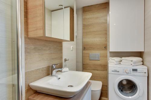 a bathroom with a sink and a washing machine at Lion Apartments - Parkowa 33Am6 z parkingiem 2 min od plazy in Sopot