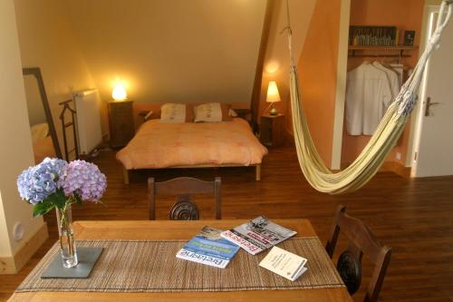 uma sala de estar com uma cama e uma mesa com flores em Loargann Chambres d'hôtes em Plogastel-Saint-Germain