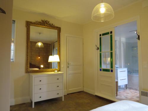 une chambre avec une commode et un miroir dans l'établissement Appartement Galerie, à Honfleur