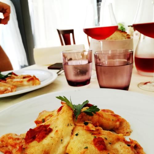 a table with two plates of food and glasses of wine at Locanda San Giorgio in Termoli