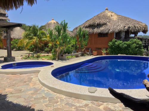 a swimming pool in front of a resort at Cabañas Las 3 Marias in San Agustinillo