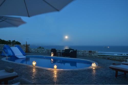 a swimming pool at night with a view of the ocean at Mastiha Villas in Chios