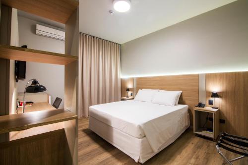 a hotel room with a bed and a television at JR Hotel in Presidente Prudente