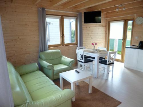 a living room with a couch and a table and chairs at Cztery Pory Roku in Trzęsacz