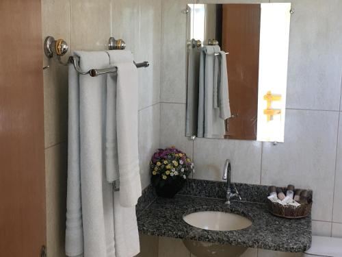 a bathroom with a sink and a mirror at Trindade Hotel in Trindade