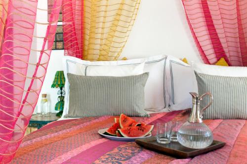 a tray with a plate of fruit on a bed at CALI Deluxe Holidays, Sesimbra in Sesimbra