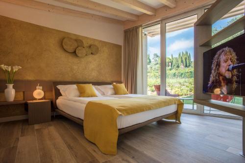 a bedroom with a bed and a large window at San Colombano Suites in Bardolino