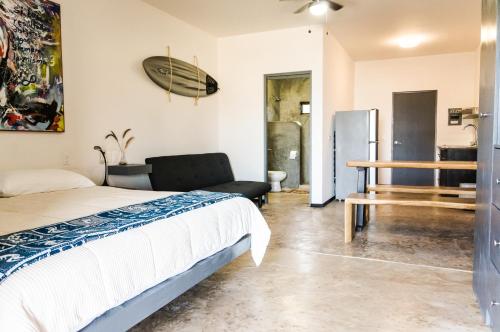 a bedroom with a bed and a surfboard on the wall at Cerritos Beach Hotel Desert Moon in El Pescadero