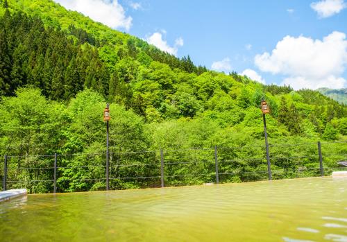 a pool of water in front of a mountain at Okuhida Garden Hotel Yakedake in Takayama