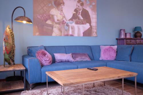a blue couch in a living room with a table at Augusta Hotel in IJmuiden