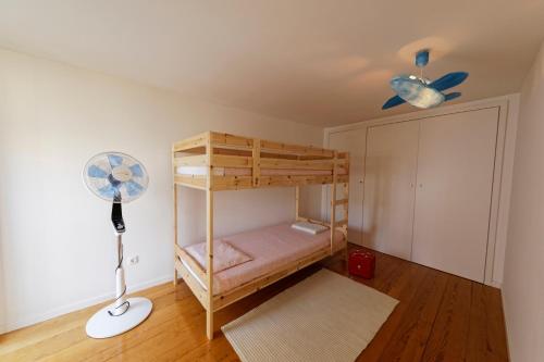 a bedroom with a bunk bed and a fan at Antiga Casa da Burra in Viseu