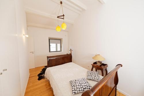 1 dormitorio con 1 cama y suelo de madera en Antiga Casa do Boi, en Viseu