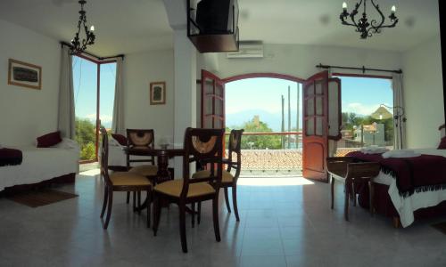a living room with a table and chairs and a bedroom at Hotel Portal del Santo in Cafayate