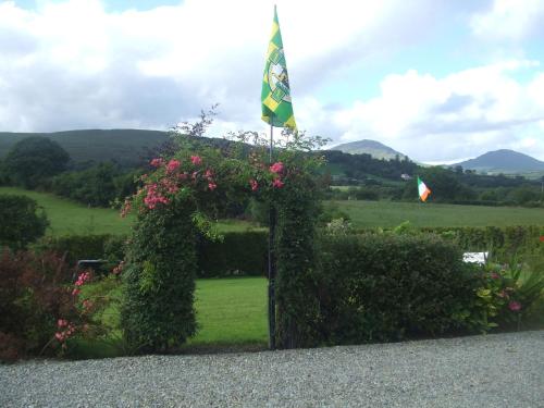 an arch with a flag and flowers in a garden at River Meadows B&B in Kenmare