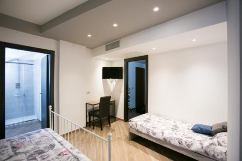 a bedroom with two beds and a desk at I Love Puglia in Conversano