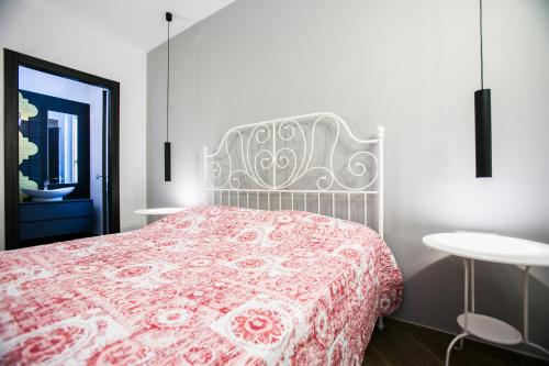 a bedroom with a bed with a red and white blanket at I Love Puglia in Conversano