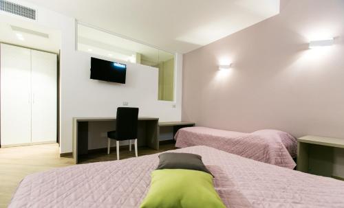 a bedroom with two beds and a desk and a mirror at I Love Puglia in Conversano