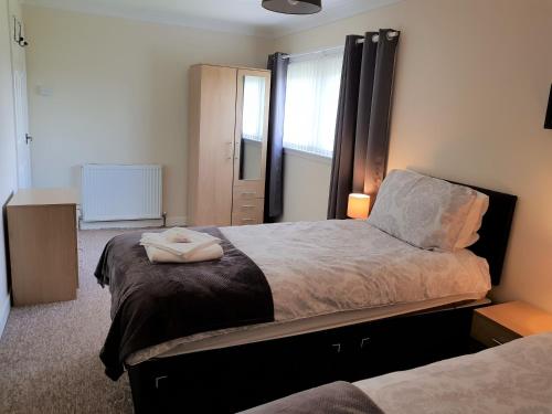 a bedroom with two beds and a window at Workforce Property in Kirk of Shotts